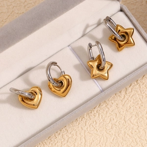 Dettaglio di orecchini a cuore e stella bicolore oro e argento in una scatola regalo