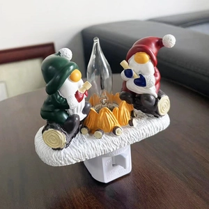 Close-up of Christmas gnome night light with festive campfire and snowy base design
