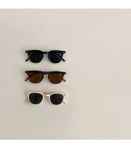 Vue à plat de lunettes de soleil rétro pour enfants en noir, écaillé et beige