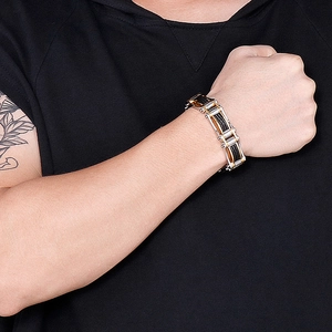 Close-up of men's stainless steel twisted chain bracelet in gold and black on wrist
