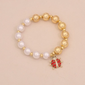 Detailed view of beaded bracelet with white pearls and red ladybug enamel pendant