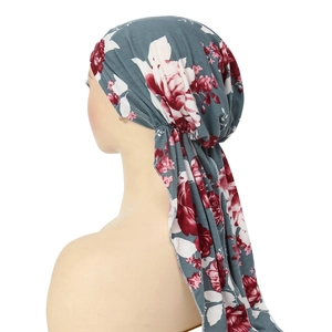 Detail of grey turban hat with red flower print and long pleated tail design