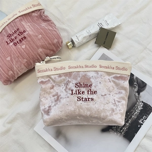 Primo piano della borsa cosmetica in velluto con ricamo 'Shine Like the Stars' di lusso