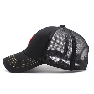 Detail view of black mesh truck hat with yellow curved stitching on the brim