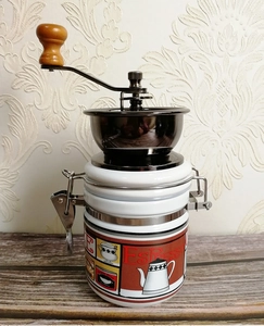 Detail of manual coffee grinder with ceramic jar and vintage espresso pattern