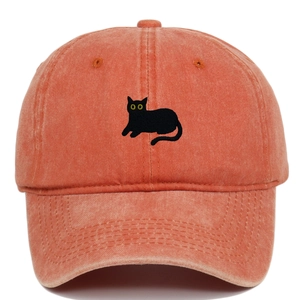 Detailed embroidery of a black cat on a washed orange vintage cotton baseball cap