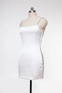 Détail de mini robe en soie blanche avec fines bretelles ornées de strass brillants