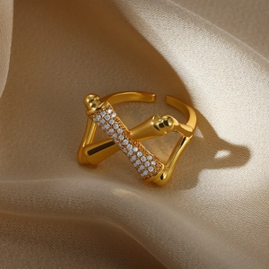 Close-up of golden open ring with micro-set zircon accents on soft beige silk