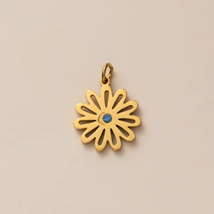 Gros plan détaillé d'un pendentif fleur en or avec une pierre de zircone bleue centrale