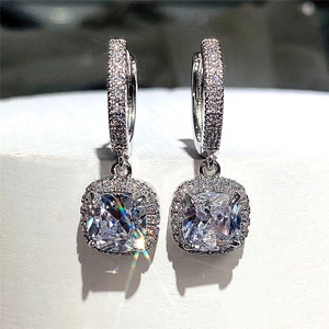 Detail of square-cut zircon earrings with pavé setting in polished silver finish