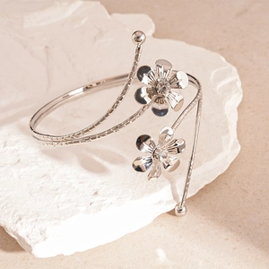 Close-up of a silver floral arm cuff featuring crystal-encrusted flower details