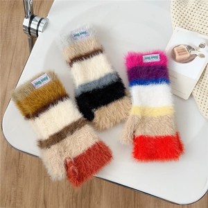 Cozy colorful striped fingerless knit gloves with plush lining on a white chair