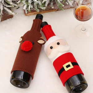 Close-up of knitted Santa and Reindeer wine bottle covers with festive pine needle decor