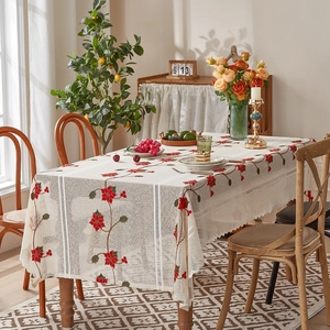 Detail of beige lace tablecloth with red poinsettia floral patterns for holiday decor