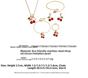 Gedetailleerd overzicht van rode kersensieradenset met ketting, armband en ring met blaadjes