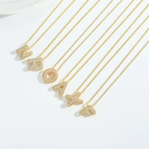 Gold plated curb chain necklaces with pavé crystal initial pendants in a minimalist setting