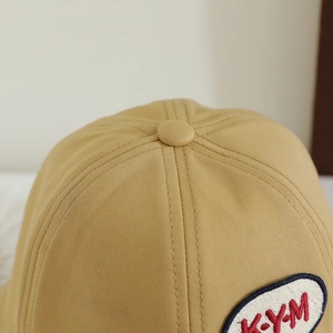 Nahaufnahme des khakifarbenen Baby-Sonnenhuts mit KYM-Stickerei und feinen Nähten