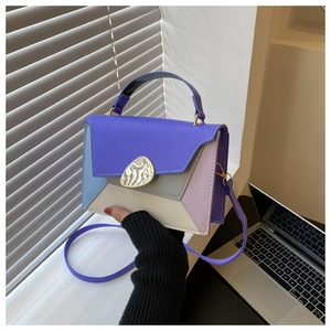 Detail of color-block handbag with geometric stitching and irregular metal buckle clasp