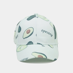Close-up detail of canvas baseball cap with green avocado print and text embroidery