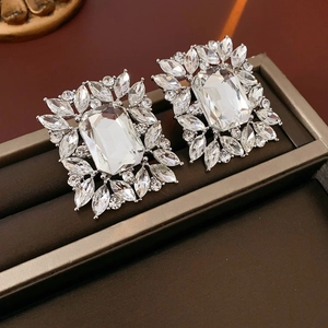 Macro shot of silver square stud earrings with faceted crystals and emerald-cut stones