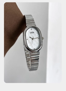Detailed close-up of a silver GEDI watch featuring a white mother-of-pearl oval dial