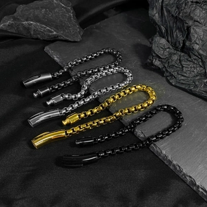 Three men's box chain bracelets in silver, gold, and black steel on dark rock background