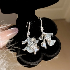 Macro shot of silver petal earrings with sparkling zircons in a velvet gift box