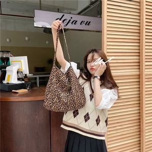 Detailed view of the large leopard print canvas tote bag carried by a model in a store