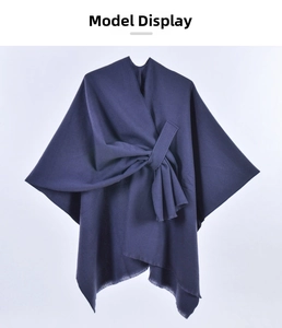 Detail of navy blue cape shawl with front tie knot and frayed fringe hem texture