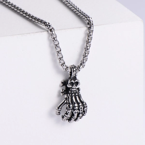 Detailed side view of punk skull hand claw pendant with oxidized silver finish and chain