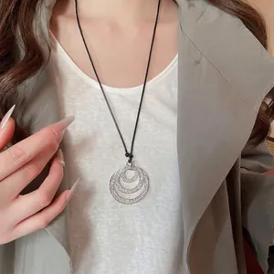 Sparkling crystal layered triple circle pendant necklace with a black cord on a model