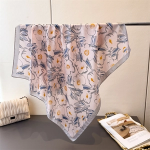 Detailaufnahme des Seidentuchs mit Blumenmuster und blauen Blüten auf rosa Stoff