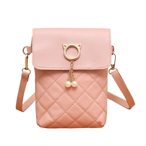 Pink quilted shoulder bag with gold cat-ear ring and pearl tassel on white background