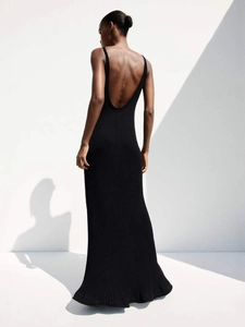 Elegant backless black knit maxi dress with vertical ribbed texture and floor-length hem