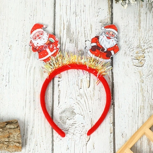 Detail of red Christmas headband featuring glitter tinsel and festive Santa Claus patches