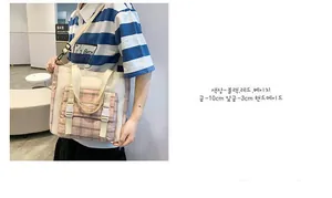 Detail of canvas shoulder bag with pink plaid pocket and fashion lettering detail