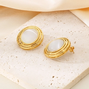 Detail of gold layered stainless steel earrings with oval opal on a stone base