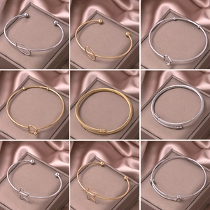 Minimalist gold and silver heart-shaped open bracelets with woven metal textures