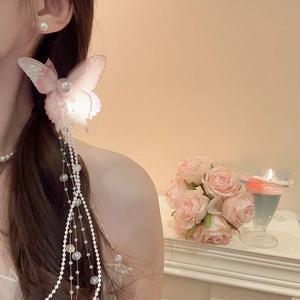 Detail of pink butterfly hair clip with mesh wings and long pearl tassel on model