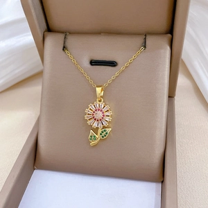Detail of sunflower pendant with zircon stones and red gem on a jewelry box