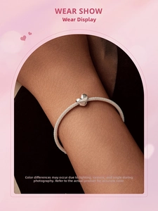 Close-up of a 925 sterling silver heart charm on a sleek snake chain bracelet worn on wrist
