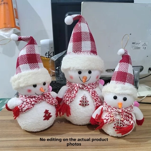 Three glowing plush snowmen with red plaid hats and scarves on a wooden table