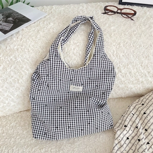 Macro view of checkered canvas tote bag with heart patterns and woven brand label