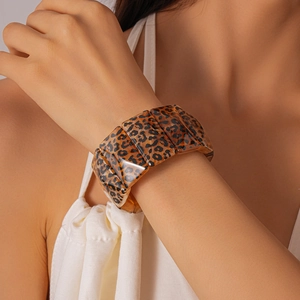 Detail of chunky acrylic link bracelet featuring retro leopard print patterns on model