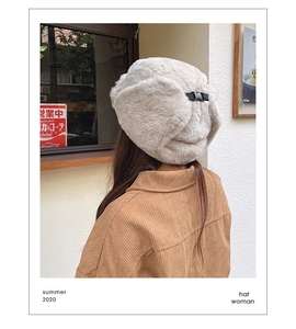 Detail view of beige plush trapper hat with adjustable buckle on the back for winter