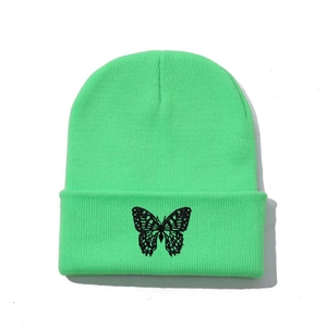 Close-up of butterfly embroidery on neon green knit beanie with folded brim detail