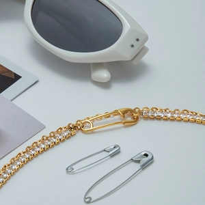 Detailed view of gold zircon bracelet featuring a unique safety pin clasp design