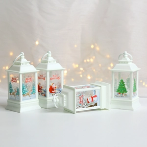 Set of four white Christmas lanterns featuring reindeer, Santa, snowman and tree designs