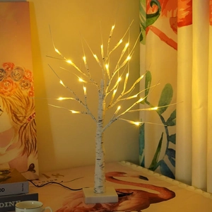 Detail of warm LED lights on white birch tree lamp with realistic bark texture for decoration