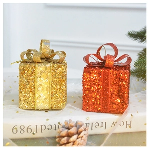 Detail of red and gold Christmas gift box ornaments with sequins and festive bow ribbons
